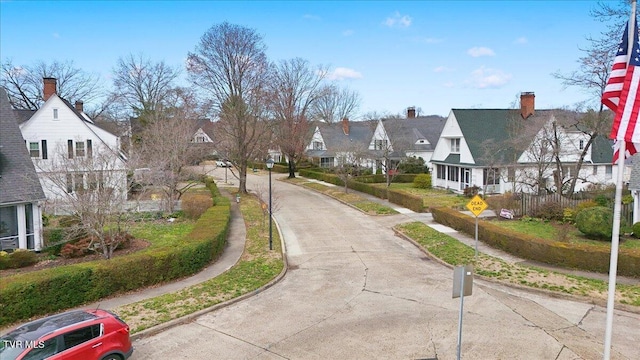 view of street featuring a residential view, curbs, traffic signs, and sidewalks