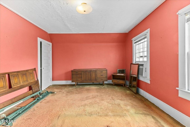 spare room featuring baseboards, carpet floors, and a textured ceiling