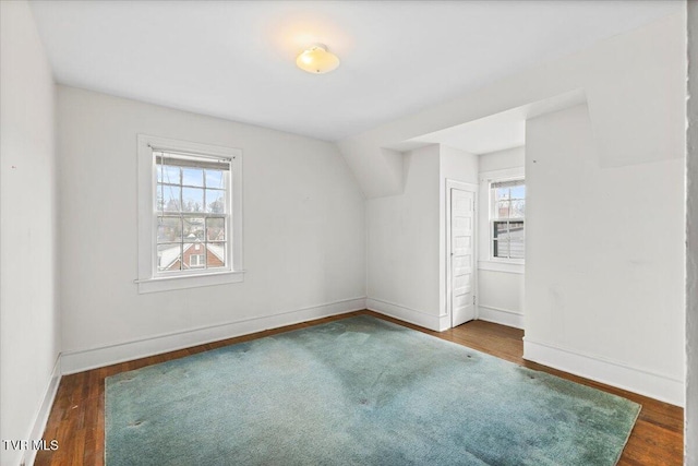 bonus room with baseboards, lofted ceiling, and wood finished floors