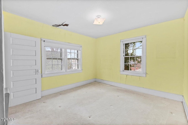 unfurnished room with baseboards and carpet