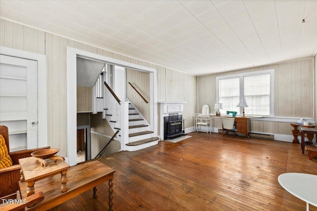 interior space with stairs, a baseboard heating unit, and hardwood / wood-style floors