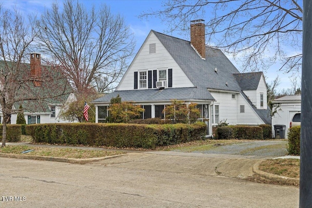 view of front of house with roof with shingles and a chimney