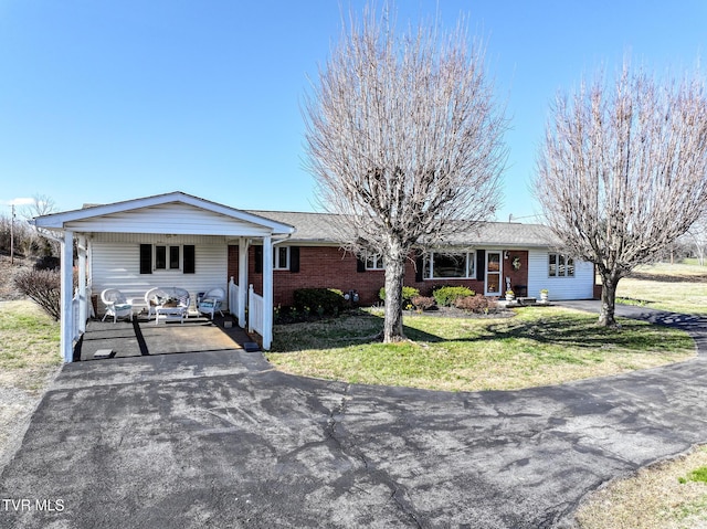 ranch-style house with brick siding, driveway, and a front yard