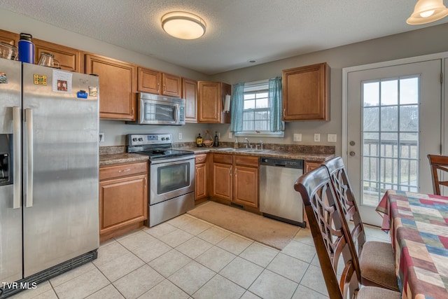 kitchen with a sink, brown cabinets, and stainless steel appliances