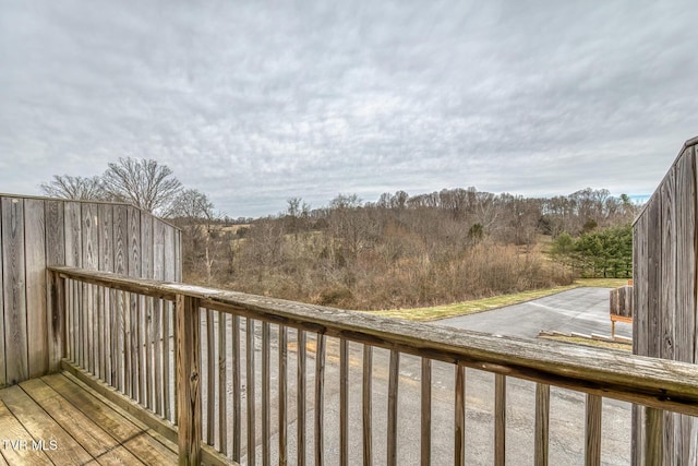 wooden terrace featuring a wooded view