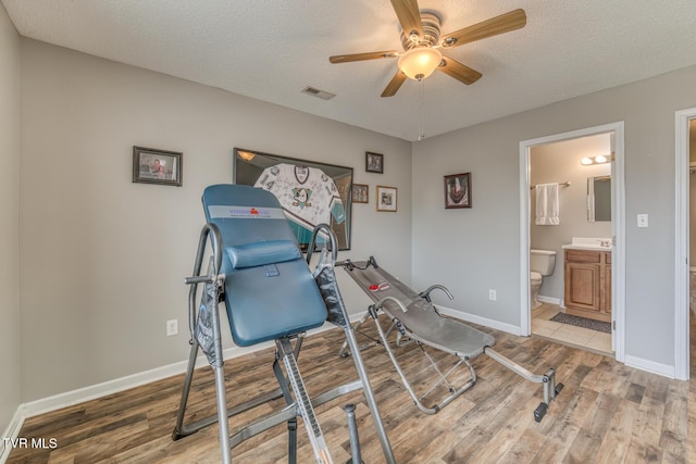 workout room featuring wood finished floors, visible vents, and baseboards