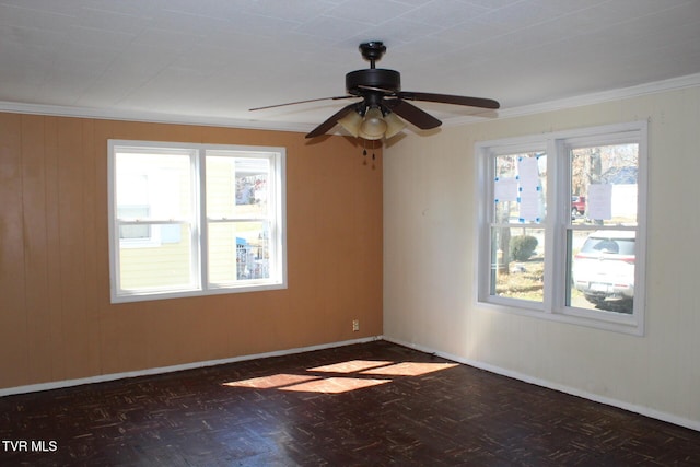 empty room with baseboards, plenty of natural light, ornamental molding, and a ceiling fan