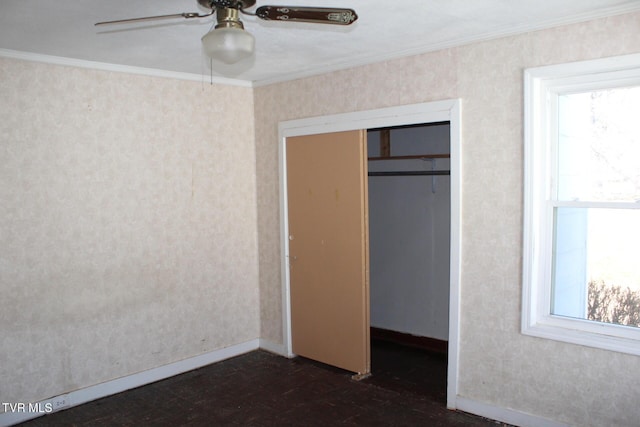 unfurnished bedroom featuring wallpapered walls, ceiling fan, baseboards, ornamental molding, and a closet