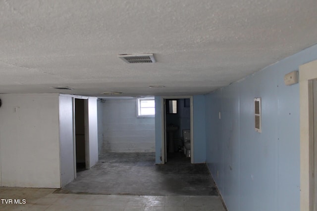 below grade area with visible vents and a textured ceiling