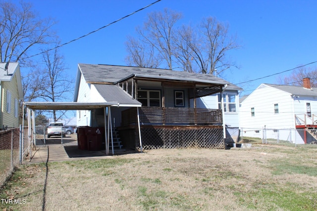 back of property featuring driveway, a gate, fence, a yard, and an attached carport