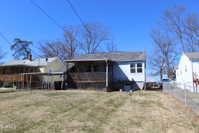 rear view of property with a lawn and fence