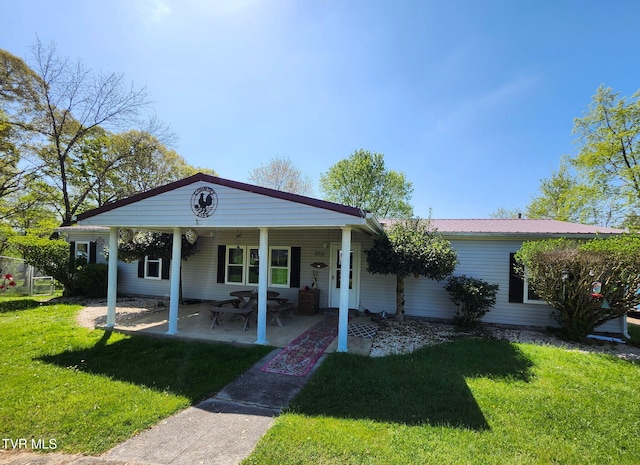 view of front of property with a front lawn, a patio area, and metal roof