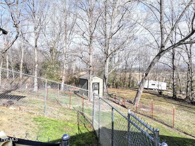 view of yard with an outdoor structure, fence, and a shed