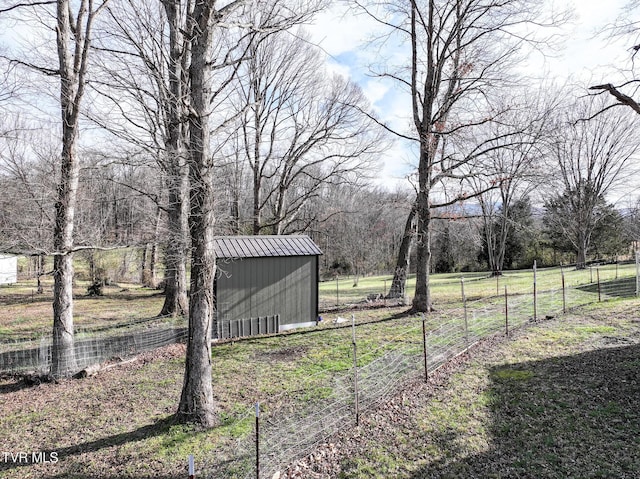 view of yard with a storage shed, an outbuilding, and fence