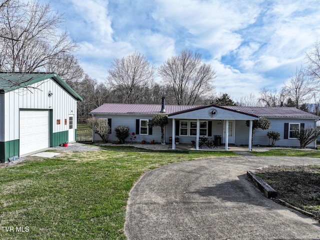 view of front of house featuring metal roof, a front lawn, a garage, and driveway