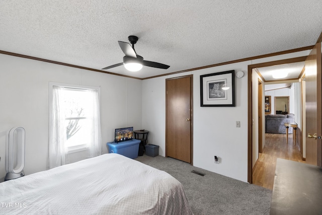 bedroom featuring visible vents, a ceiling fan, a textured ceiling, a closet, and crown molding