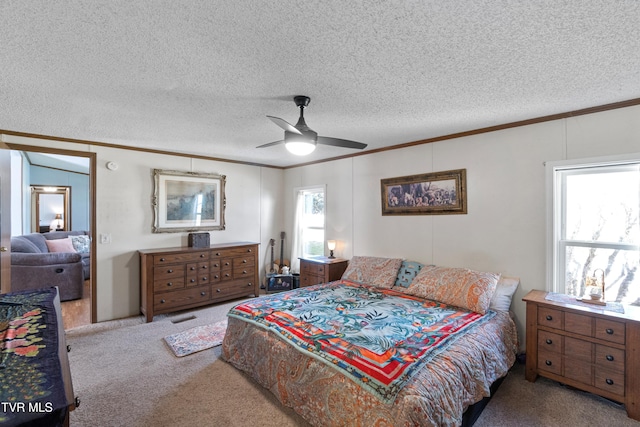 bedroom with crown molding, a ceiling fan, carpet floors, and a textured ceiling