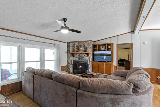 living area featuring lofted ceiling with beams, light wood-type flooring, plenty of natural light, and wainscoting