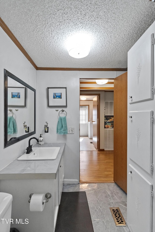 bathroom featuring visible vents, a textured ceiling, toilet, and ornamental molding