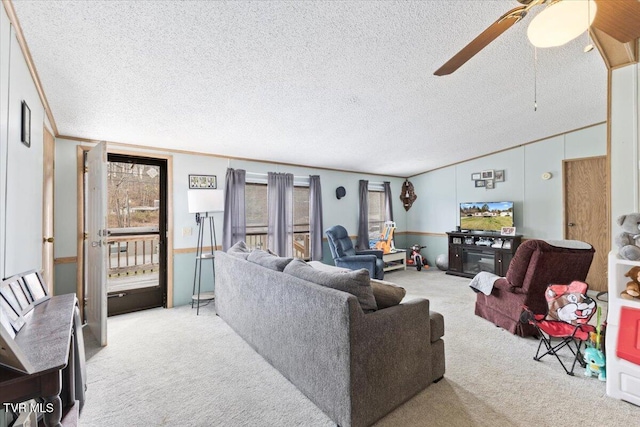 living room with a textured ceiling, carpet, crown molding, ceiling fan, and vaulted ceiling