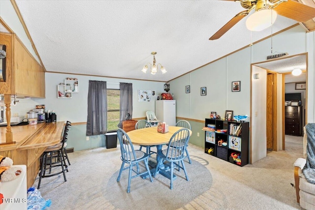 dining area featuring light carpet, ceiling fan with notable chandelier, a textured ceiling, crown molding, and lofted ceiling