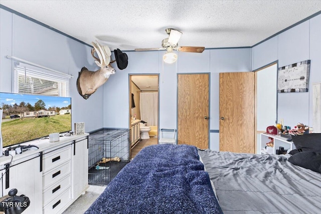 bedroom featuring ceiling fan, ensuite bath, and a textured ceiling