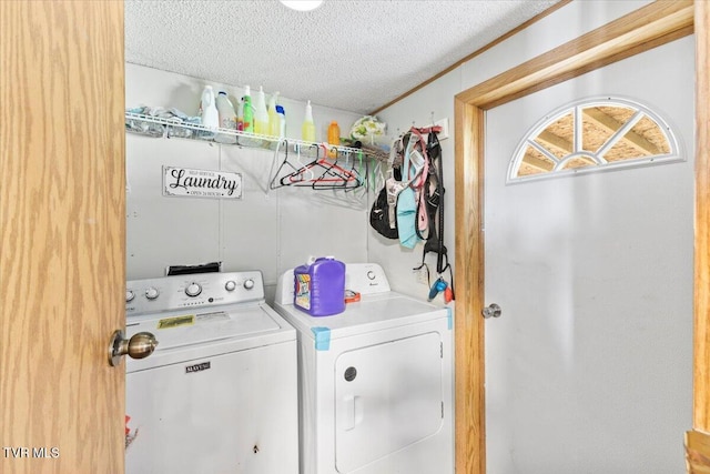 laundry room featuring washing machine and clothes dryer, laundry area, and a textured ceiling