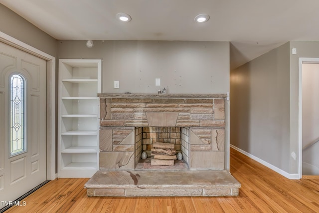 details featuring built in features, wood finished floors, baseboards, recessed lighting, and a fireplace