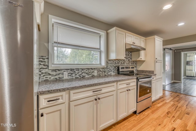 kitchen featuring under cabinet range hood, tasteful backsplash, recessed lighting, stainless steel appliances, and light wood-style floors