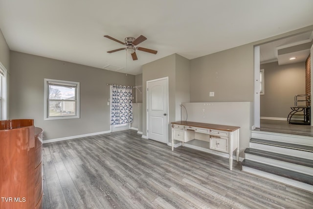 interior space with wood finished floors, baseboards, and ceiling fan