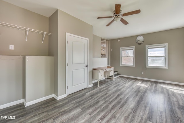 unfurnished living room with ceiling fan, baseboards, and wood finished floors