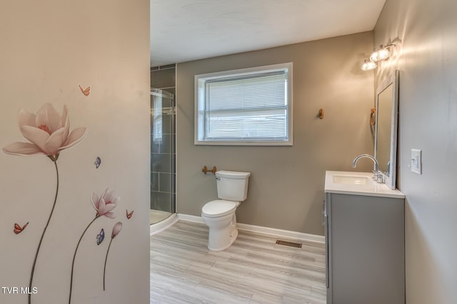 full bath featuring tiled shower, baseboards, toilet, and vanity