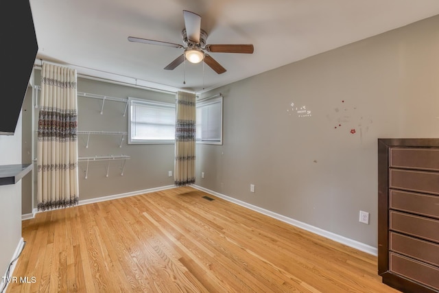 unfurnished bedroom featuring a closet, ceiling fan, baseboards, and wood finished floors