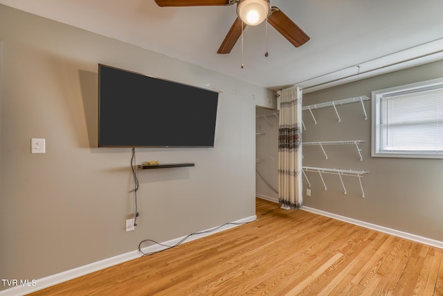 unfurnished living room featuring baseboards, light wood-style floors, and ceiling fan