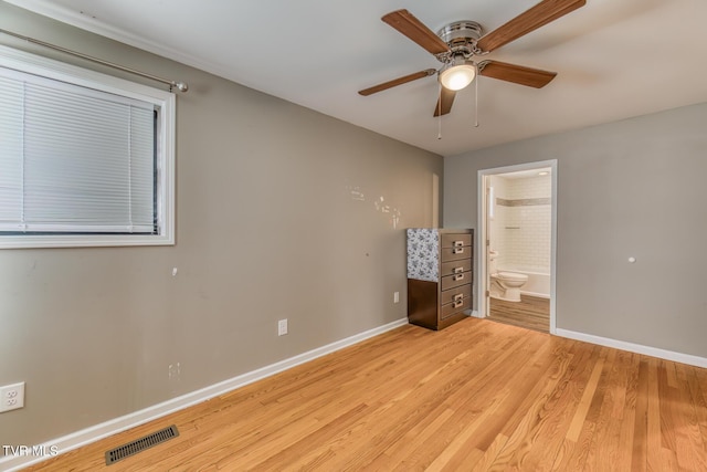 unfurnished bedroom featuring visible vents, connected bathroom, light wood-type flooring, and baseboards