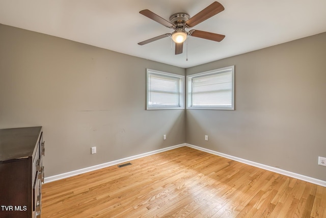 unfurnished room with visible vents, light wood-style flooring, baseboards, and ceiling fan