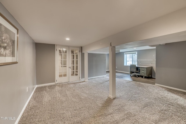 below grade area featuring french doors, baseboards, and carpet floors