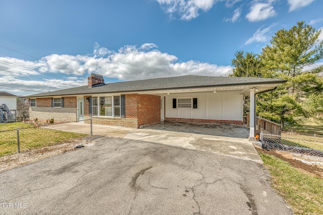 ranch-style home featuring a carport, driveway, a chimney, and fence