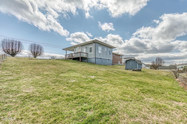 rear view of house with fence, crawl space, a yard, an outbuilding, and a storage unit