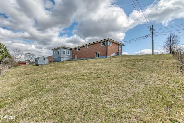 view of yard with a storage shed, an outdoor structure, and fence