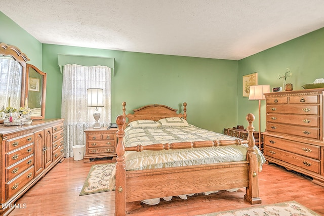 bedroom featuring light wood-style floors and a textured ceiling