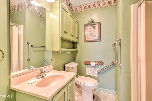 bathroom with toilet, vanity, and baseboards