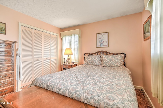 bedroom featuring a closet, baseboards, and a textured ceiling