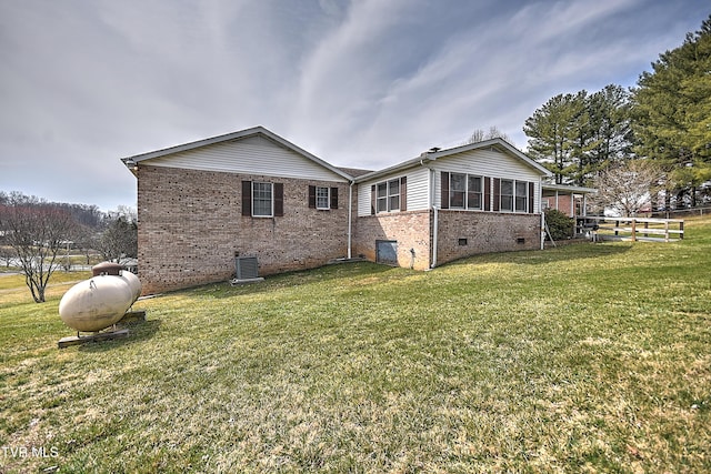 view of home's exterior with fence, crawl space, central air condition unit, a lawn, and brick siding