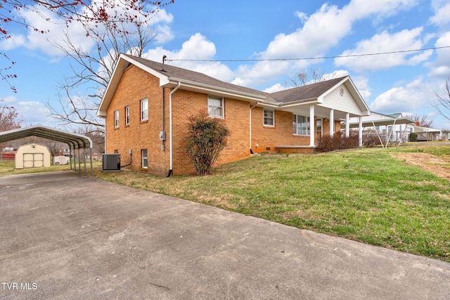 view of property exterior featuring cooling unit, covered porch, concrete driveway, a lawn, and brick siding