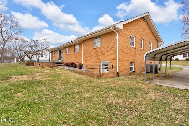 view of side of home with central AC, fence, a yard, a detached carport, and brick siding