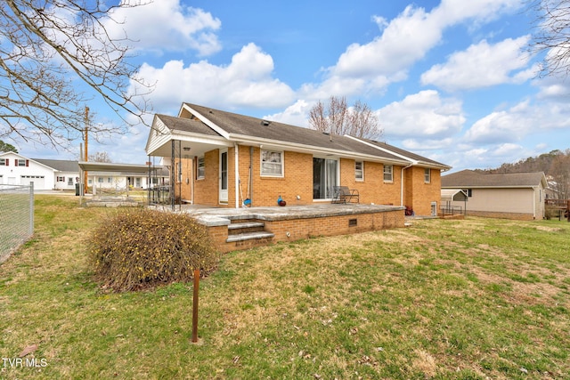 back of house with a lawn, a patio, fence, a carport, and brick siding