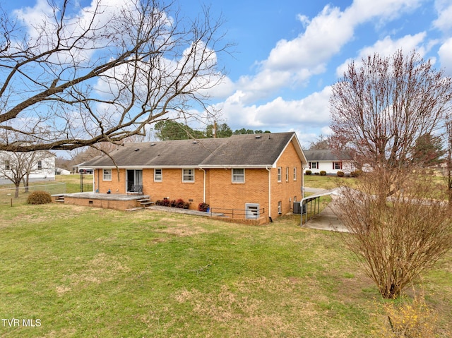 rear view of property featuring fence, a yard, central AC, crawl space, and brick siding