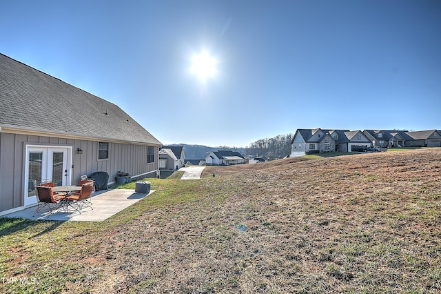 view of yard with a patio, french doors, and a residential view