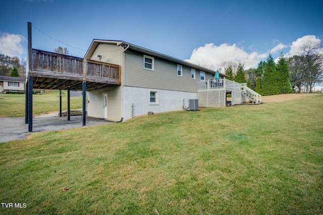 rear view of property with a wooden deck, stairs, central air condition unit, a patio area, and a lawn